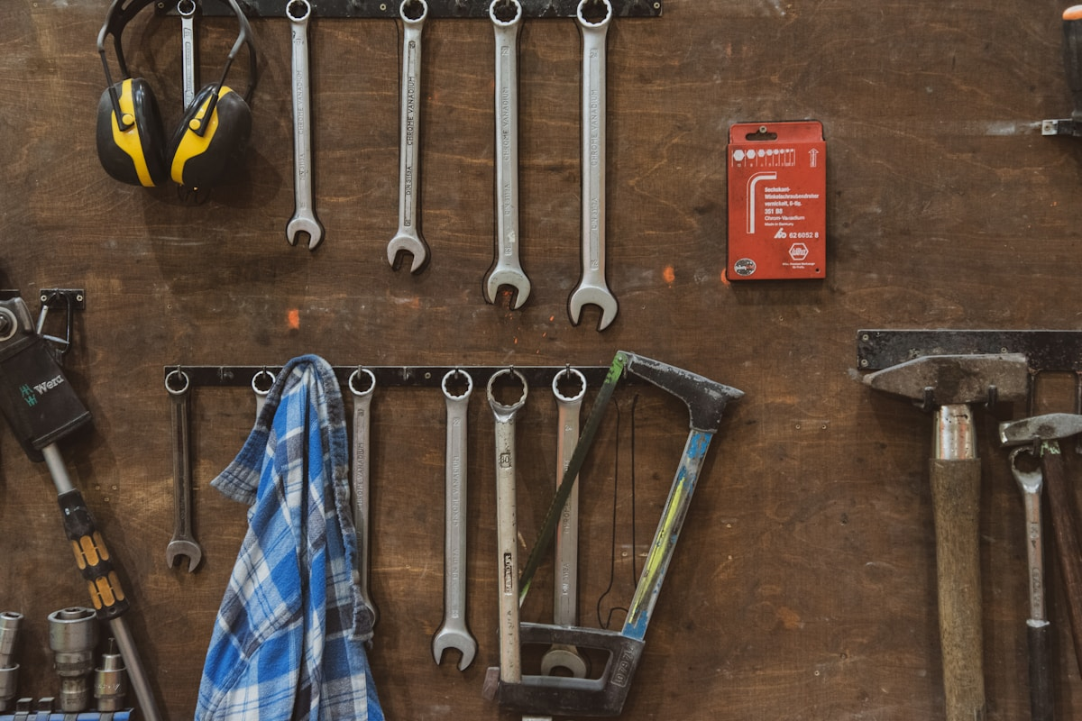 Wrenches and hand tools hanging on a workshop wall